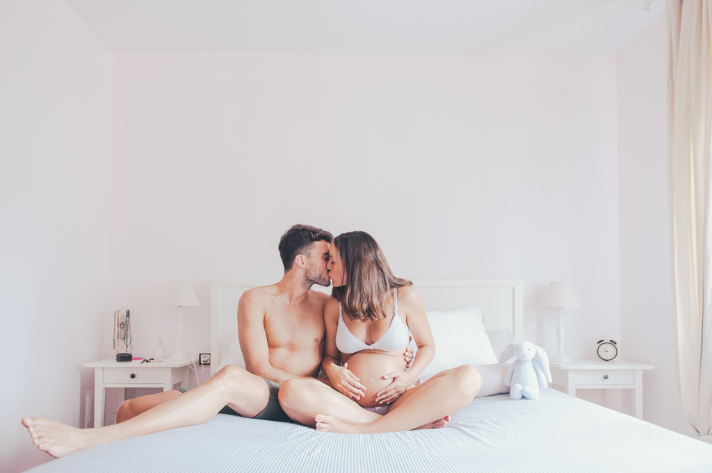 pareja-embarazo-beso-habitacion-cama
